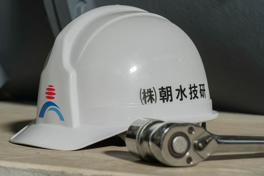 朝水技研のロゴ入りヘルメットと工具